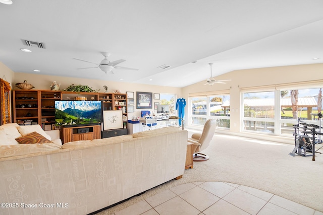tiled living area with lofted ceiling, carpet floors, visible vents, and a ceiling fan