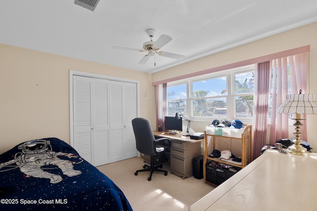 carpeted bedroom with a ceiling fan, a closet, and visible vents