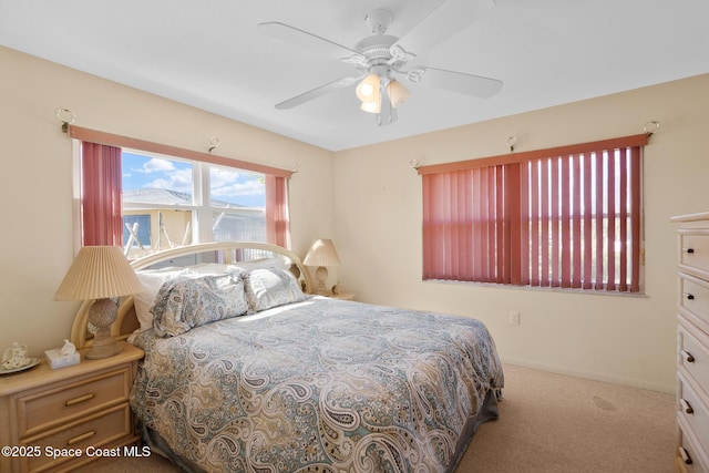 carpeted bedroom with ceiling fan and baseboards