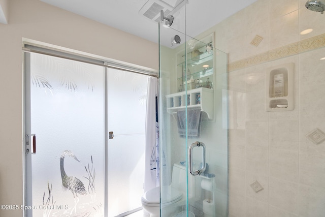 bathroom featuring a stall shower and toilet