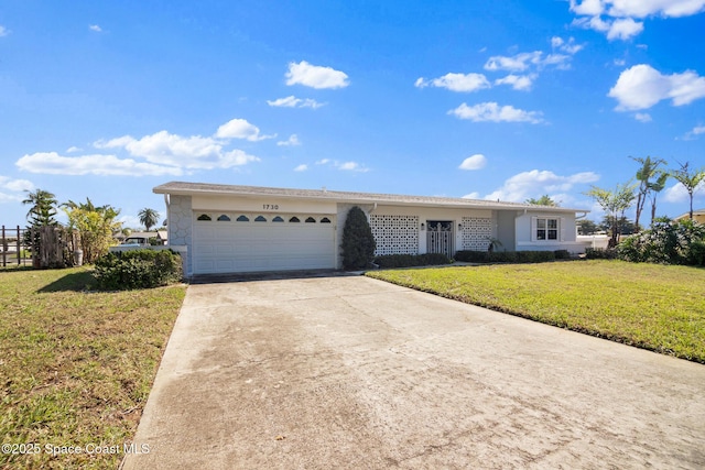 ranch-style house featuring an attached garage, a front lawn, and concrete driveway