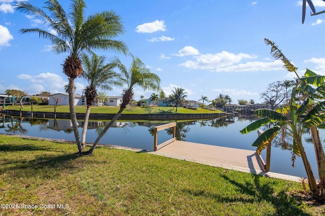 view of dock with a water view, a residential view, and a yard