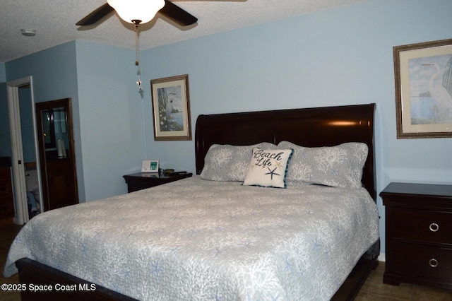 tiled bedroom featuring a ceiling fan and a textured ceiling