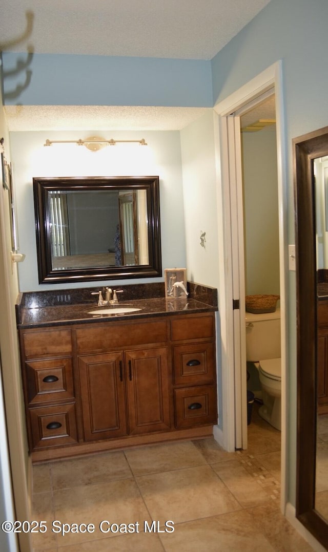 bathroom featuring toilet, tile patterned floors, and vanity