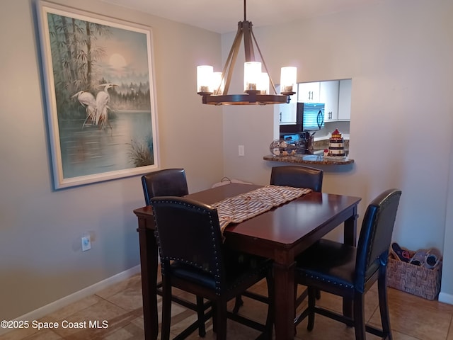 dining room with light tile patterned floors, baseboards, and a notable chandelier