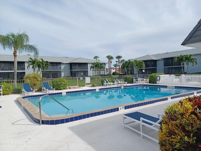 community pool featuring fence and a patio