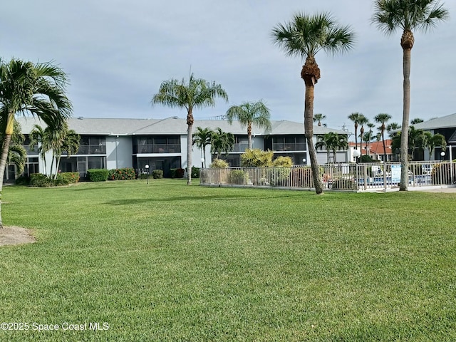 exterior space with a lawn, fence, and a residential view