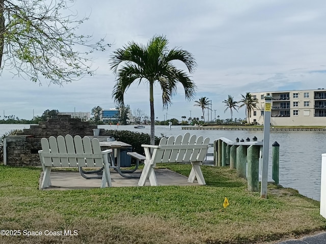 dock area with a water view and a yard