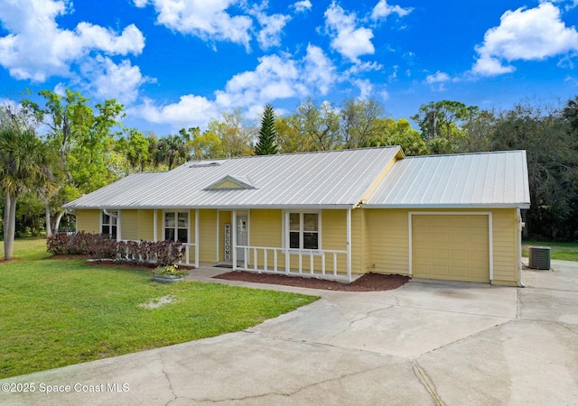 single story home with driveway, an attached garage, covered porch, cooling unit, and a front yard