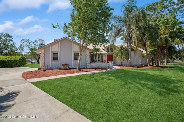 view of front facade featuring stucco siding, driveway, and a front yard