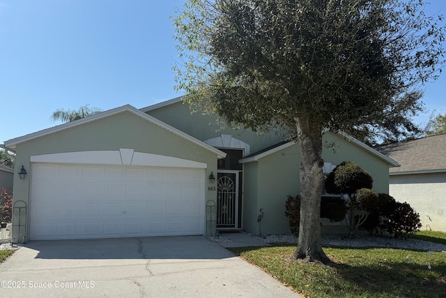 ranch-style house with a garage, concrete driveway, and stucco siding