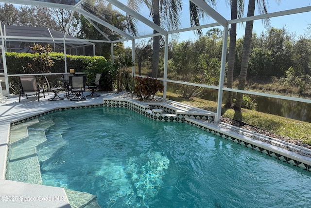 outdoor pool featuring a patio, glass enclosure, and an in ground hot tub