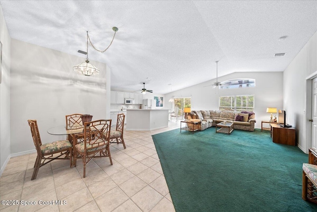 living area with light tile patterned floors, visible vents, a ceiling fan, lofted ceiling, and a textured ceiling