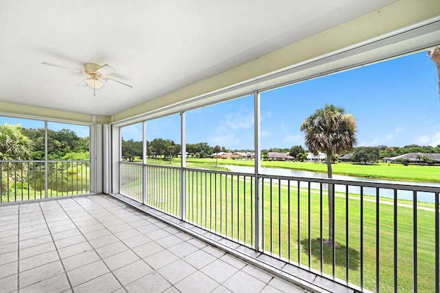 unfurnished sunroom with ceiling fan and a water view