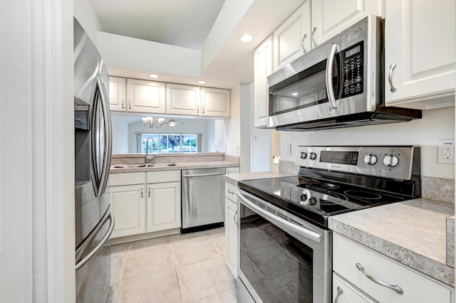 kitchen featuring white cabinets, stainless steel appliances, a sink, and light countertops