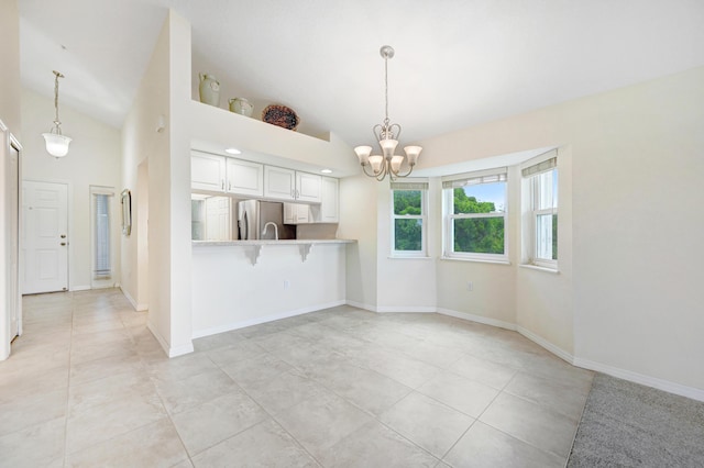 kitchen with a chandelier, pendant lighting, baseboards, and stainless steel fridge with ice dispenser