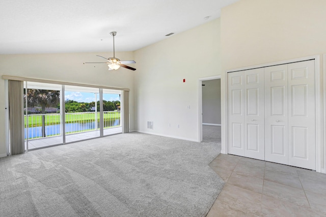 interior space with ceiling fan, high vaulted ceiling, carpet floors, visible vents, and baseboards