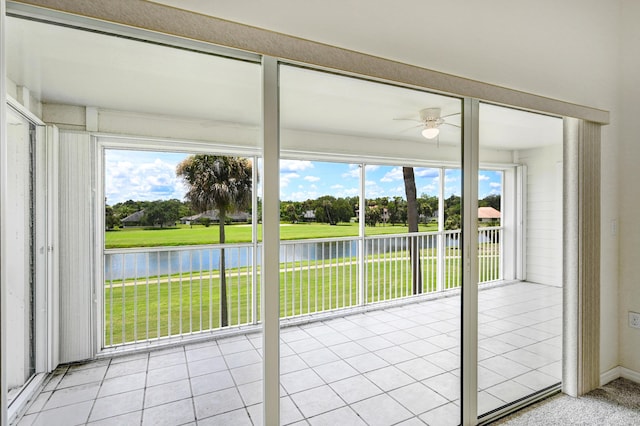 unfurnished sunroom featuring a water view and ceiling fan