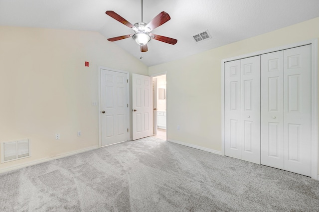 unfurnished bedroom with carpet floors, lofted ceiling, visible vents, and baseboards