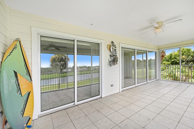 unfurnished sunroom with a wealth of natural light and ceiling fan