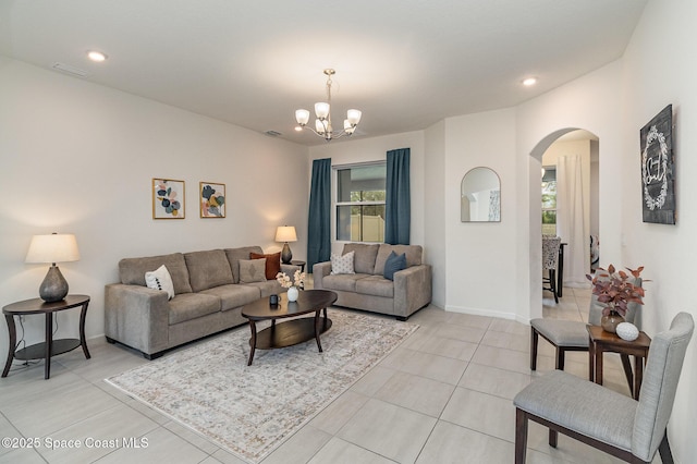 living area featuring light tile patterned floors, baseboards, arched walkways, a chandelier, and recessed lighting