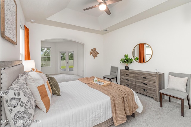 bedroom with light carpet, access to outside, arched walkways, and french doors