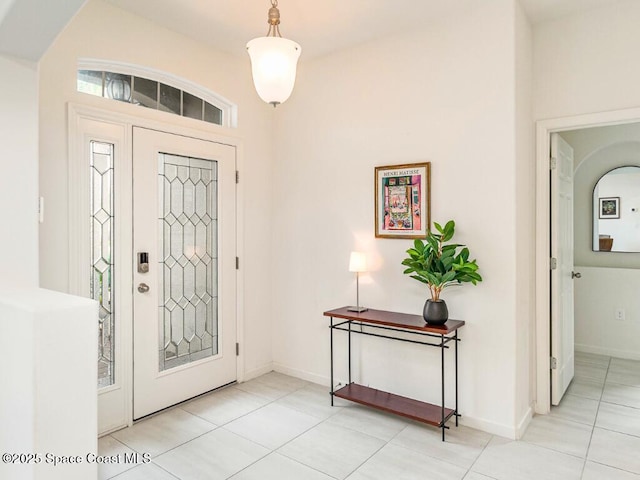 foyer featuring tile patterned flooring and baseboards