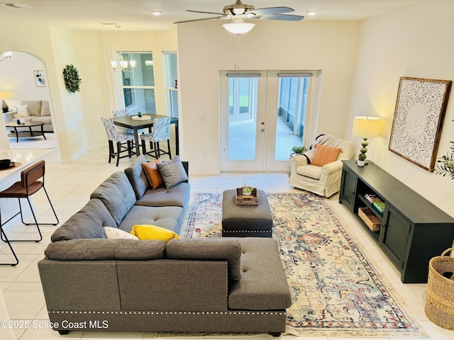 living room featuring light tile patterned floors, french doors, plenty of natural light, and arched walkways