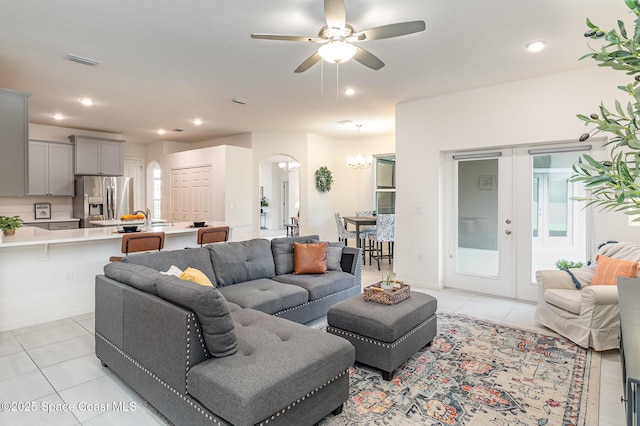 living room featuring light tile patterned floors, arched walkways, visible vents, and recessed lighting