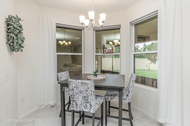 dining room with light tile patterned flooring, baseboards, and an inviting chandelier