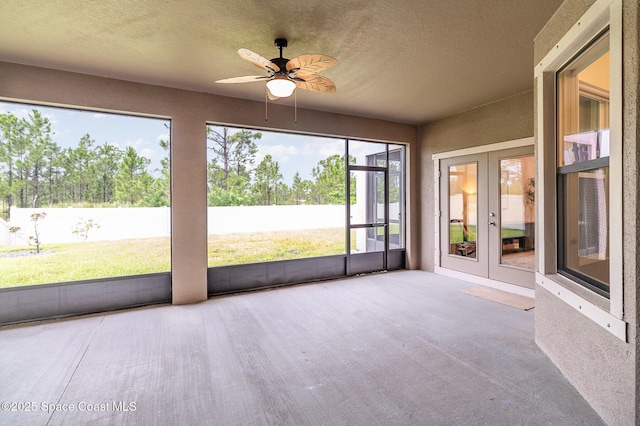 unfurnished sunroom featuring a ceiling fan and french doors