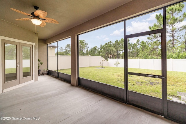 unfurnished sunroom featuring ceiling fan