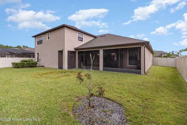 back of property featuring stucco siding, a shingled roof, a lawn, a sunroom, and a fenced backyard