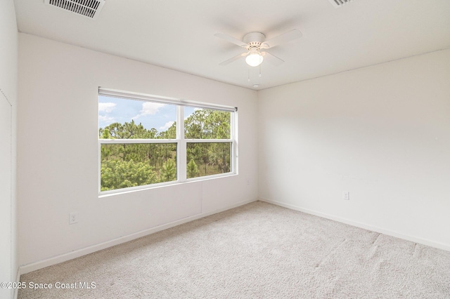 spare room with carpet, visible vents, ceiling fan, and baseboards