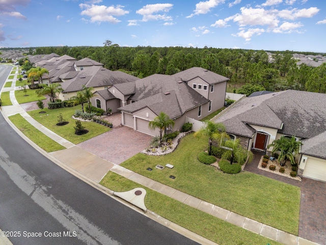 drone / aerial view featuring a residential view and a view of trees