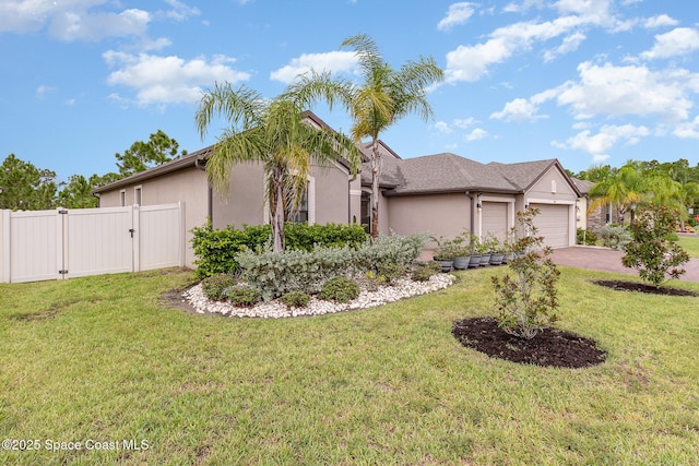 view of front of property with an attached garage, a gate, fence, and stucco siding