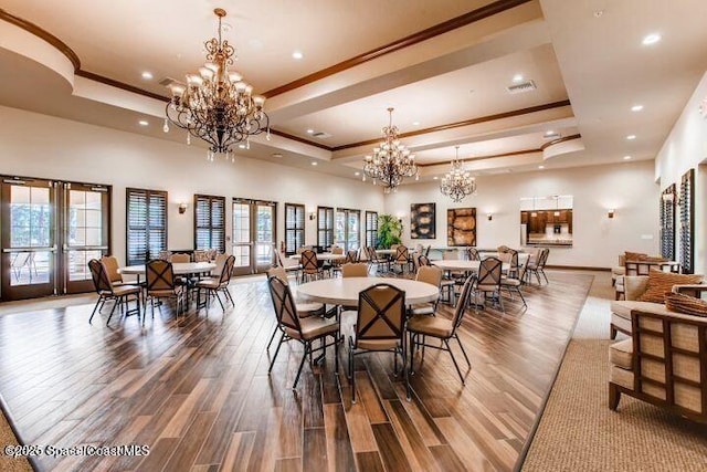 dining space featuring a tray ceiling, french doors, and a notable chandelier