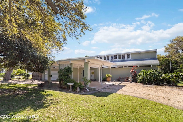 view of front facade with a front lawn and a patio