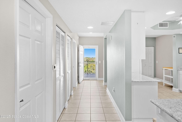 hallway featuring recessed lighting, visible vents, baseboards, and light tile patterned floors