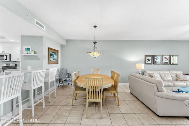 dining space with light tile patterned flooring, visible vents, and baseboards