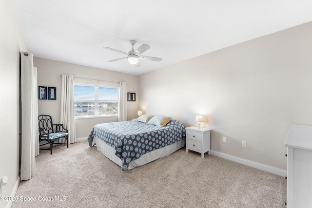 bedroom with light colored carpet, ceiling fan, and baseboards