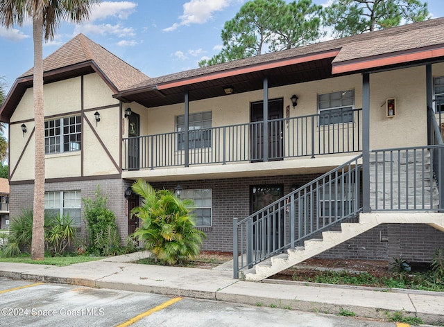 view of property featuring uncovered parking and stairway