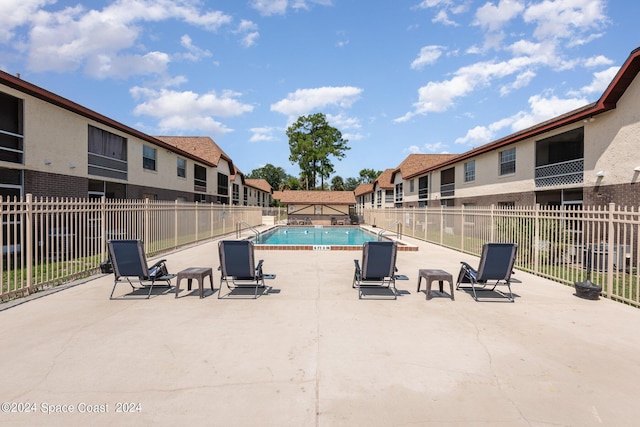 community pool featuring a residential view, a patio area, and fence