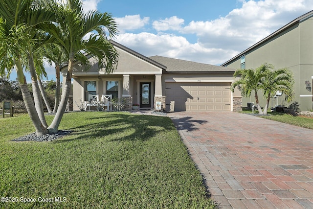 view of front facade featuring decorative driveway, stucco siding, an attached garage, a front yard, and stone siding