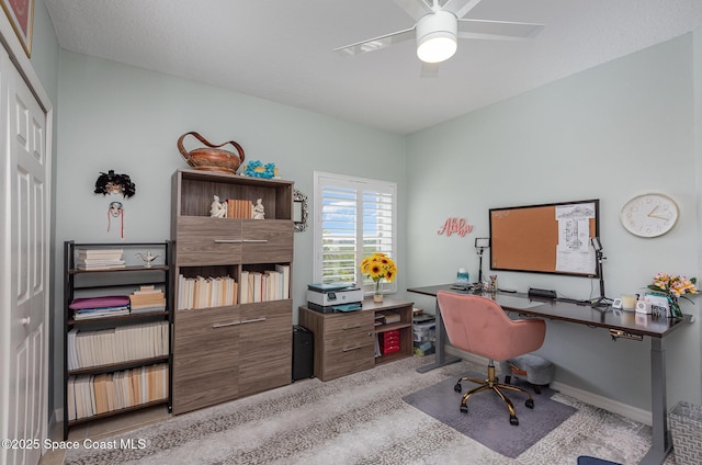 home office with a ceiling fan and baseboards