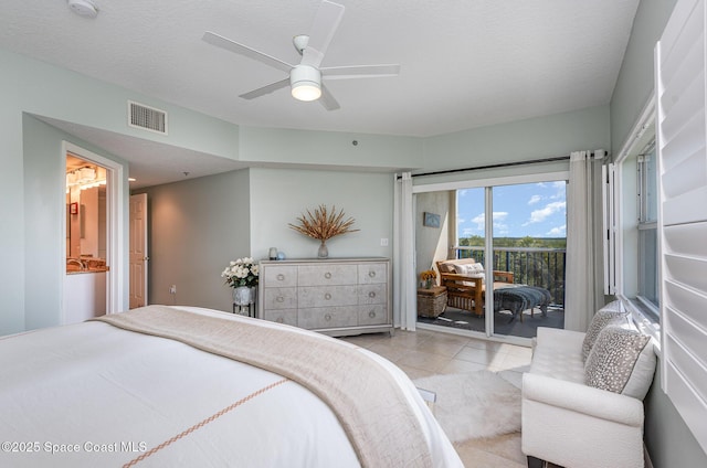 bedroom featuring visible vents, a ceiling fan, ensuite bath, tile patterned floors, and access to exterior