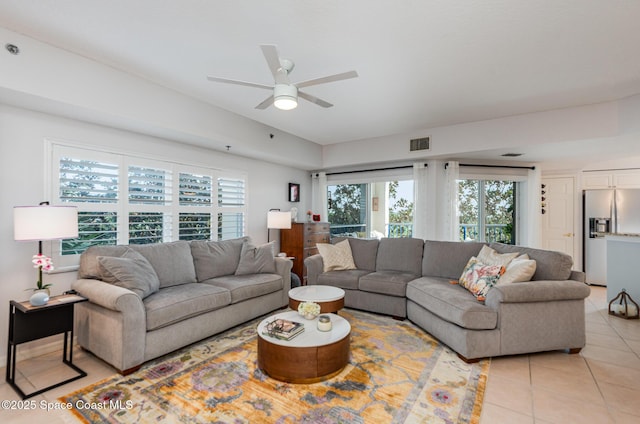 living room with light tile patterned floors, visible vents, and a ceiling fan