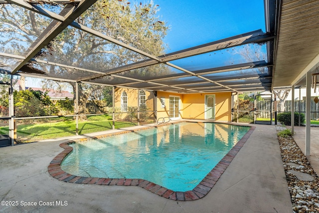 outdoor pool with a lanai, a patio area, and a lawn