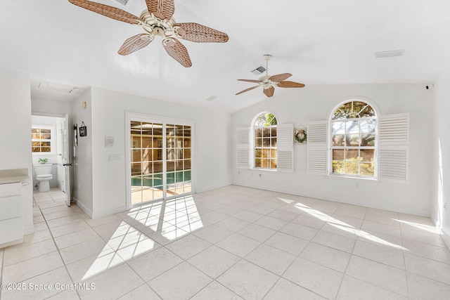 empty room featuring light tile patterned floors, lofted ceiling, visible vents, and baseboards