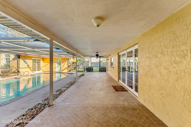 view of patio / terrace with ceiling fan, fence, a lanai, and an outdoor pool